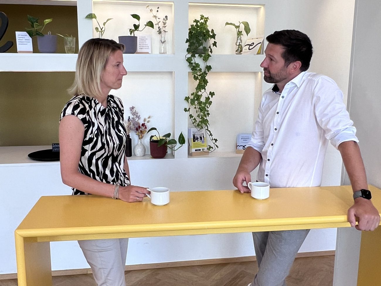 Verena Kremnitzer und René Bremböck im Gespräch an einem Stehtisch