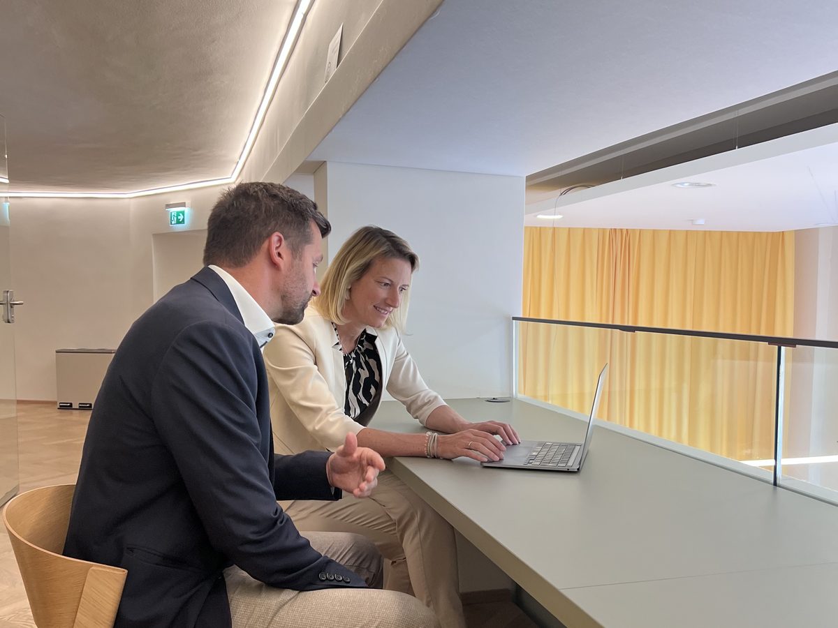 Zwei Personen arbeiten gemeinsam an einem Laptop in den Räumen von Workspace
